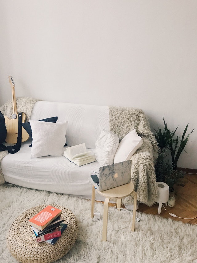 primary residence with white couch, books, and a rug of a person that doesn't have to pay capital gains tax