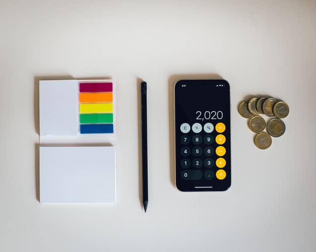 calculator, note pad, and some coins for calculating depreciation capture tax