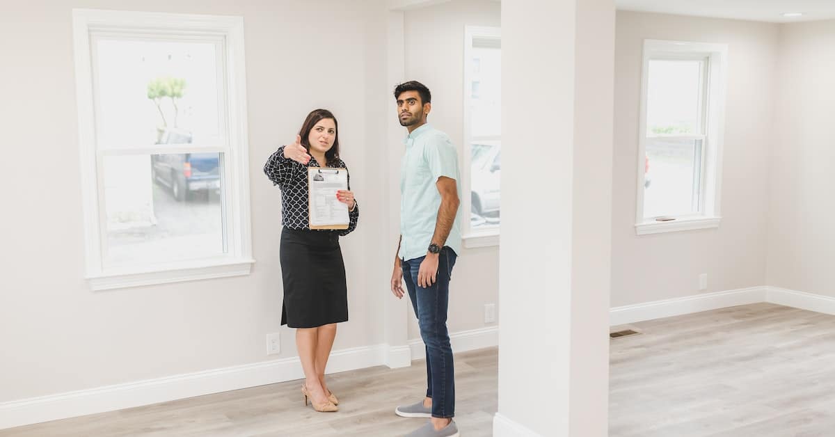 female real estate agent showing man house during real estate bubble