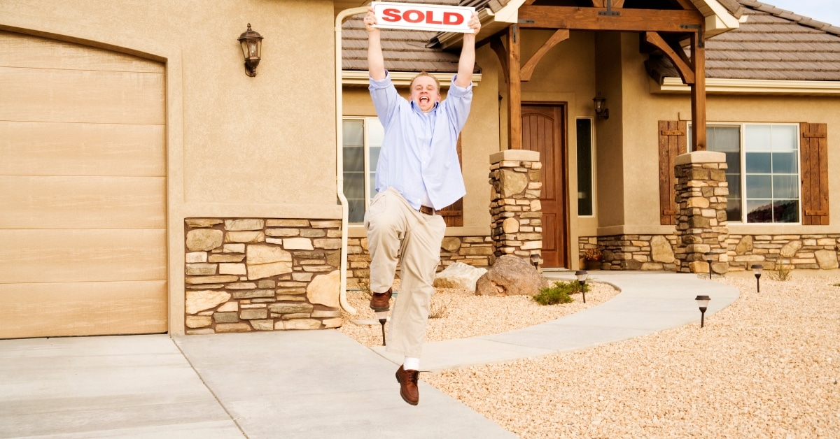 agent holding sold sign