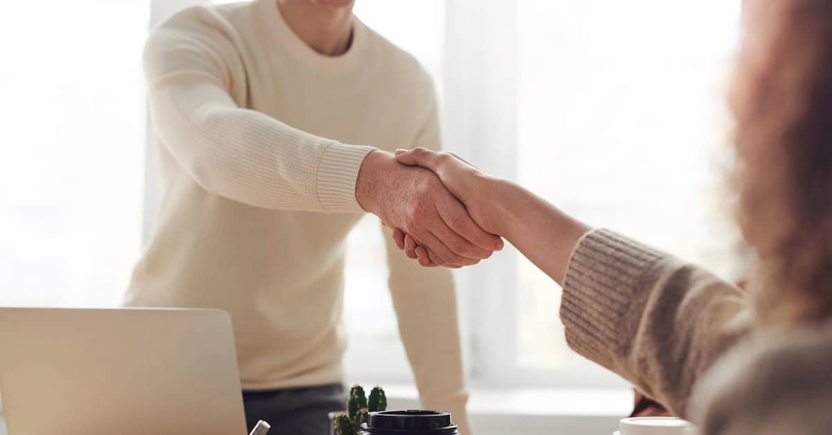 man shaking hands with woman after getting property manager job