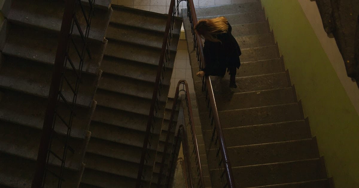 female holdover tenant looking down stairwell