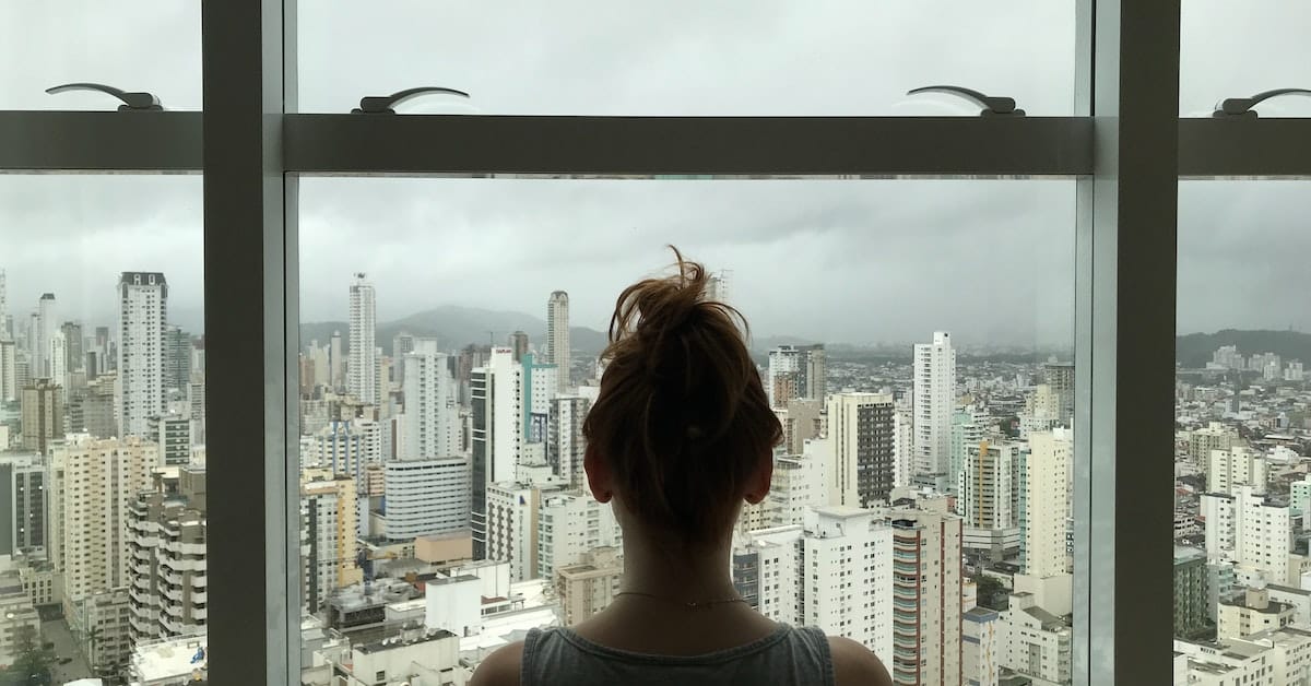 female holdover tenant looking out window